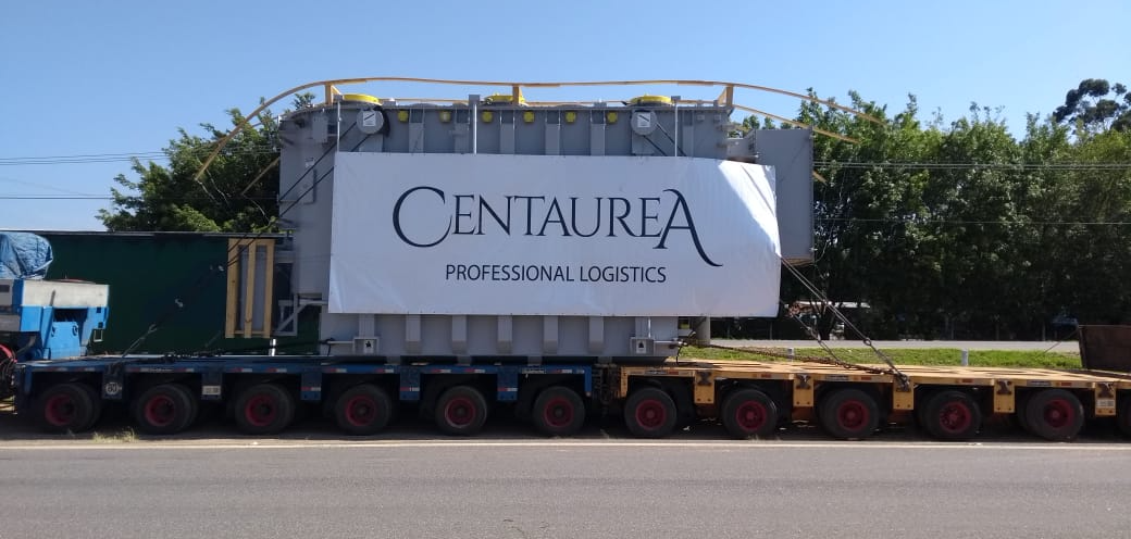 Transformador Siemens de +150 toneladas com banner Centaurea, sobre carreta multieixos